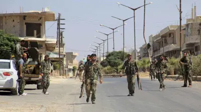 مسلحون موالون للجيش السوري في بلدة الحلفايا بحماة