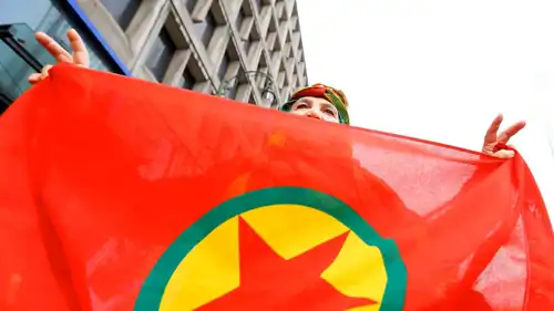 امرأة تحمل علم حزب العمال الكردستاني