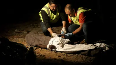 عمال إغاثة طبية  يفحصون جثة مهاجر أفريقي قبالة سواحل موريتانيا