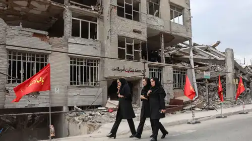  إيرانيات أمام مبنى سكني دمر خلال الحرب