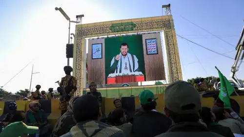 يمنيون يتابعون خطابا لزعيم ميليشيا الحوثيين