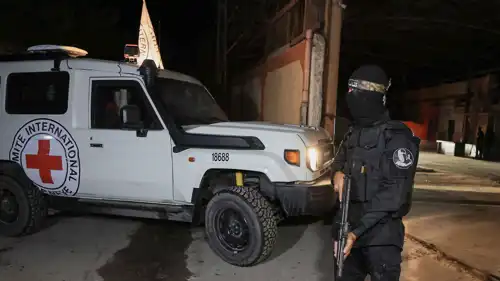 مسلح من حماس إلى جانب سيارة للصليب الأحمر في غزة