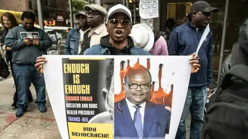 شخص يحمل صورة عمر سيسوكو إمبال