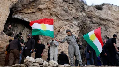 أكراد عراقيون يحملون أعلام كردستان