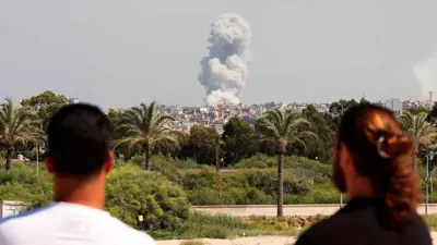 يشاهد الناس تصاعد الدخان فوق جنوب لبنان في أعقاب الضربات الإسرائيلية