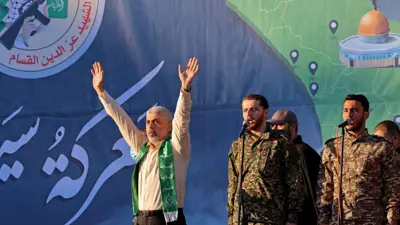 يحيى السنوار يلوح بيديه لعدد من مؤيديه خلال احتفالية سابقة في غزة