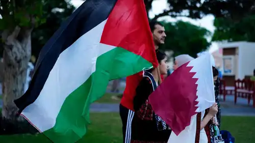 أطفال يرفعون علما فلسطين وقطر