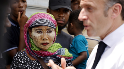 سيدة تقف بجانب الرئيس الفرنسي إيمانويل ماكرون في مايوت