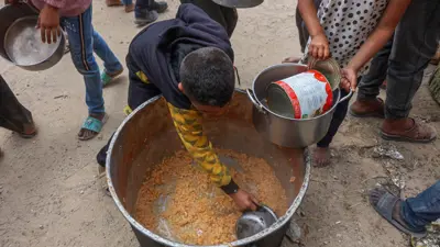أطفال يحاولون الحصول على الطعام في قطاع غزة