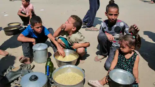 أطفال يتناولون حصص مساعدات في ظل المجاعة بغزة