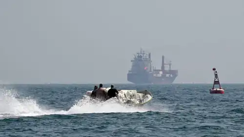 قارب محمل بالبضائع يتجاوز سفينة حاويات في مضيق هرمز