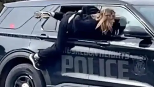 المرأة تهرب من نافذة سيارة الشرطة