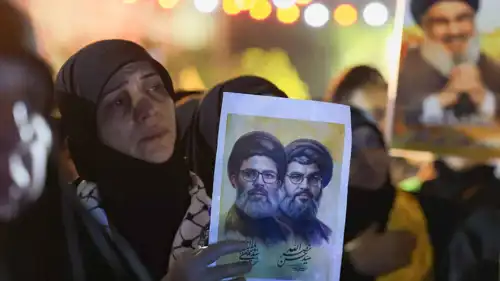 لبنانية ترفع صورة نصر الله وصفي الدين في ذكرى اغتيالهما