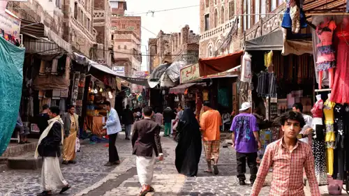أشخاص يتجولون بأحد شوارع صنعاء القديمة