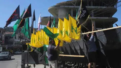 عناصر من مليشيا حزب الله اللبناني يرفعون أعلام للحزب