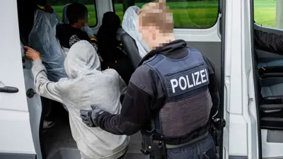 مهاجرون يستقلون سيارة تابعة للشرطة الألمانية عند الحدود مع بولندا