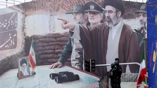 عناصر من الحرس الثوري أما لافته لمجتبى خامنئي ووالده