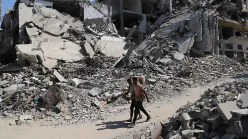 فلسطينيان يسيران بين الأنقاض في غزة