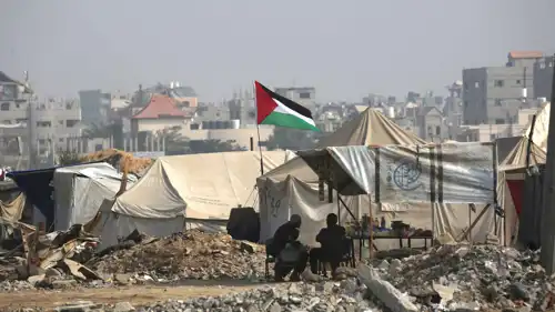 فلسطينيون جالسون في منطقة خيام في قطاع غزة