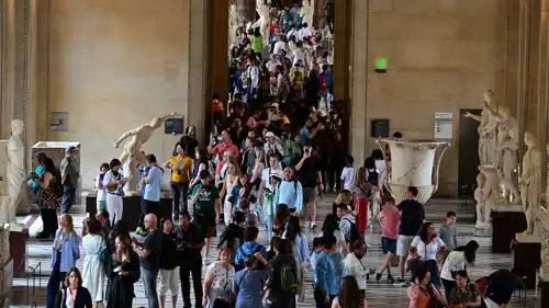 سياح وزوار أمام أحد أبواب متحف اللوفر