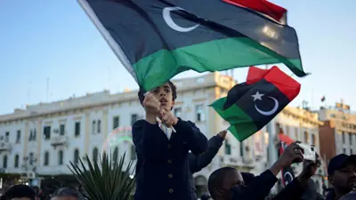 طفل يلوح بالعلم الليبي، خلال الاحتفالات في العاصمة طرابلس