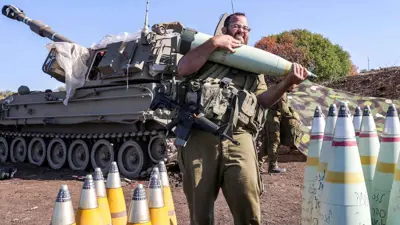 جندي إسرائيلي يحمل قذيفة مدفعية