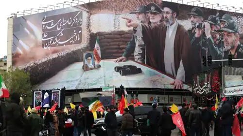 إيرانيون يسيرون أمام لوحة للمرشد الجديد مجتبى خامنئي