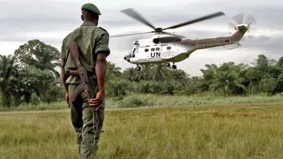 طائرة هليكوبتر أممية تحلق أمام جندي مسلح جنوب السودان
