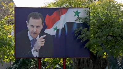 صورة ممزقة للأسد في دمشق