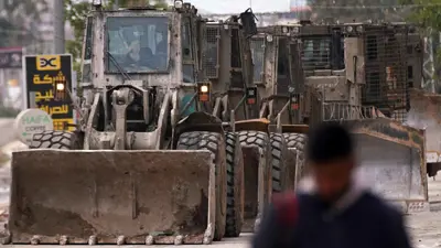 فلسطيني أمام آليات عسكرية خلال عملية جنين