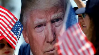 أنصار ترامب يحملون صوره والأعلام الأمريكية