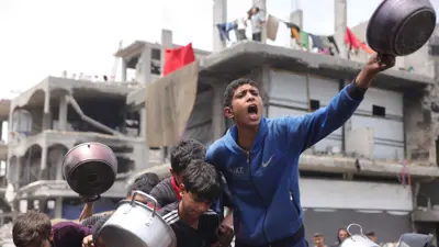 أطفال في غزة مع قدور طعام خاوية