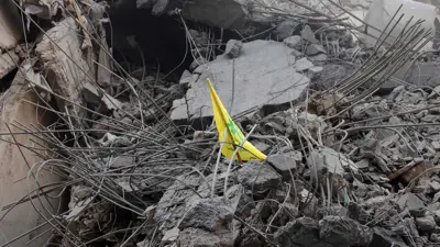 راية "حزب الله" وسط ركام مباني الضاحية الجنوبية المدمرة