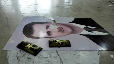 صورة ممزقة لبشار الأسد بعد سقوط نظامه