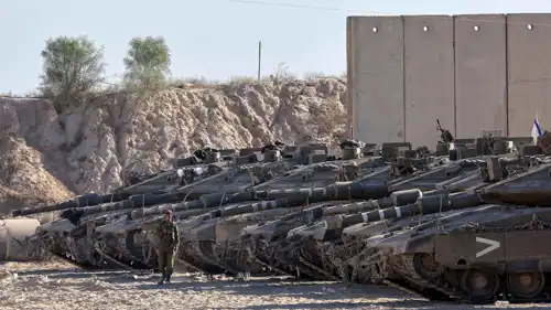 جندي إسرائيلي بجانب دبابات