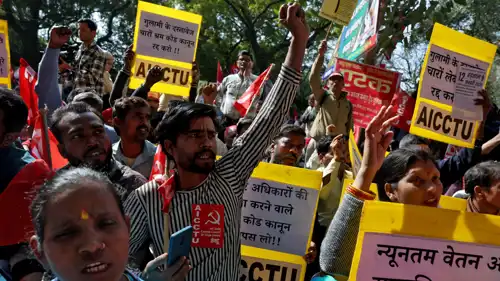 متظاهرون يرفعون لافتات خلال مشاركتهم في الإضراب