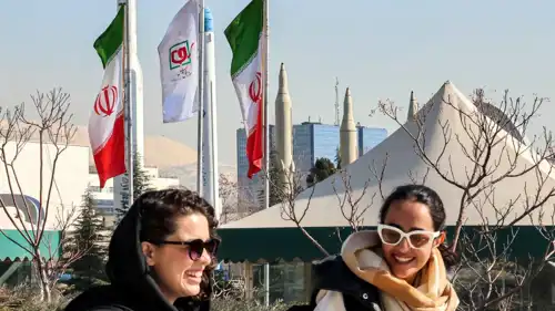 نساء يمررن أمام نماذج من الصواريخ الباليستية الإيرانية