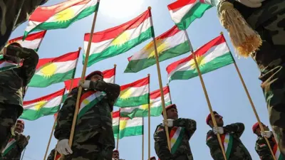 أعلام كردية خلال احتفال عسكري بأربيل عاصمة إقليم كردستان