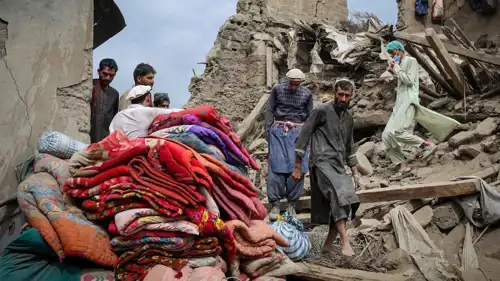 رجال أفغان يبحثون بين أنقاض منزل دمره زلزال 