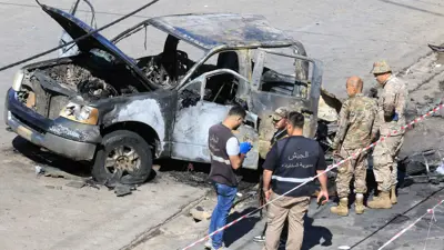 جنود من الجيش اللبناني يتفقدون مركبة محترقة 