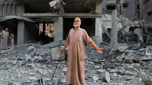 فلسطينيون يتفقدون موقع القصف الإسرائيلي على منازل في مخيم الشاطئ