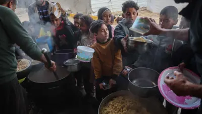 أطفال غزة يقفون في طابور أمام مطبخ خيري
