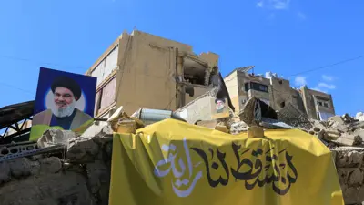 صورة لحسن نصر الله القتيل معلّقة على أنقاض بناية دمرت بقصف إسرائيلي