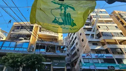راية حزب الله مقابل شقة متضررة من قصف بيروت