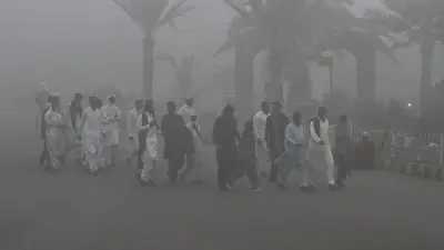 أشخاص يسيرون وسط الضباب الدخاني في باكستان