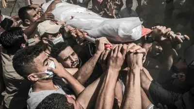 غزيون يحملون أحد الضحايا 