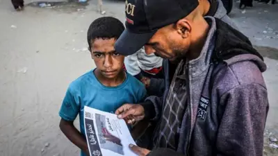 فلسطيني يقرأ منشوراً ألقاه الجيش الإسرائيلي