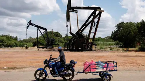 فنزويلي يمر أمام مضخة نفط مدمرة