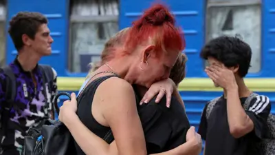 امرأة تعانق أقاربها في بوكروفسك قبل صعود القطار إلى أوكرانيا