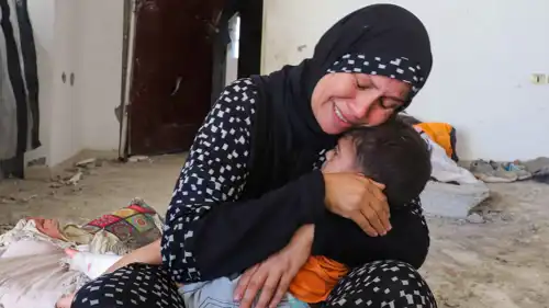 سيدة فلسطينية من غزة مع طفلها 